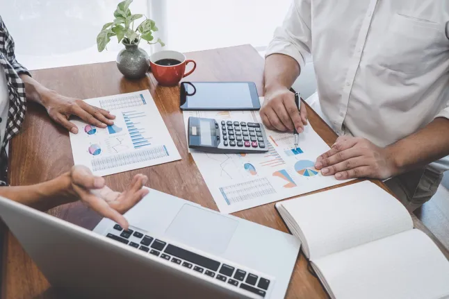 Dwie osoby przy biurku omawiające dokumenty