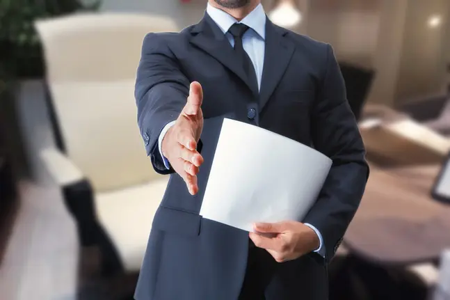 A man in a suit extending his hand in greeting